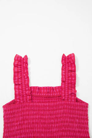 Pink gingham sundress with smocked bodice and ruffled straps.