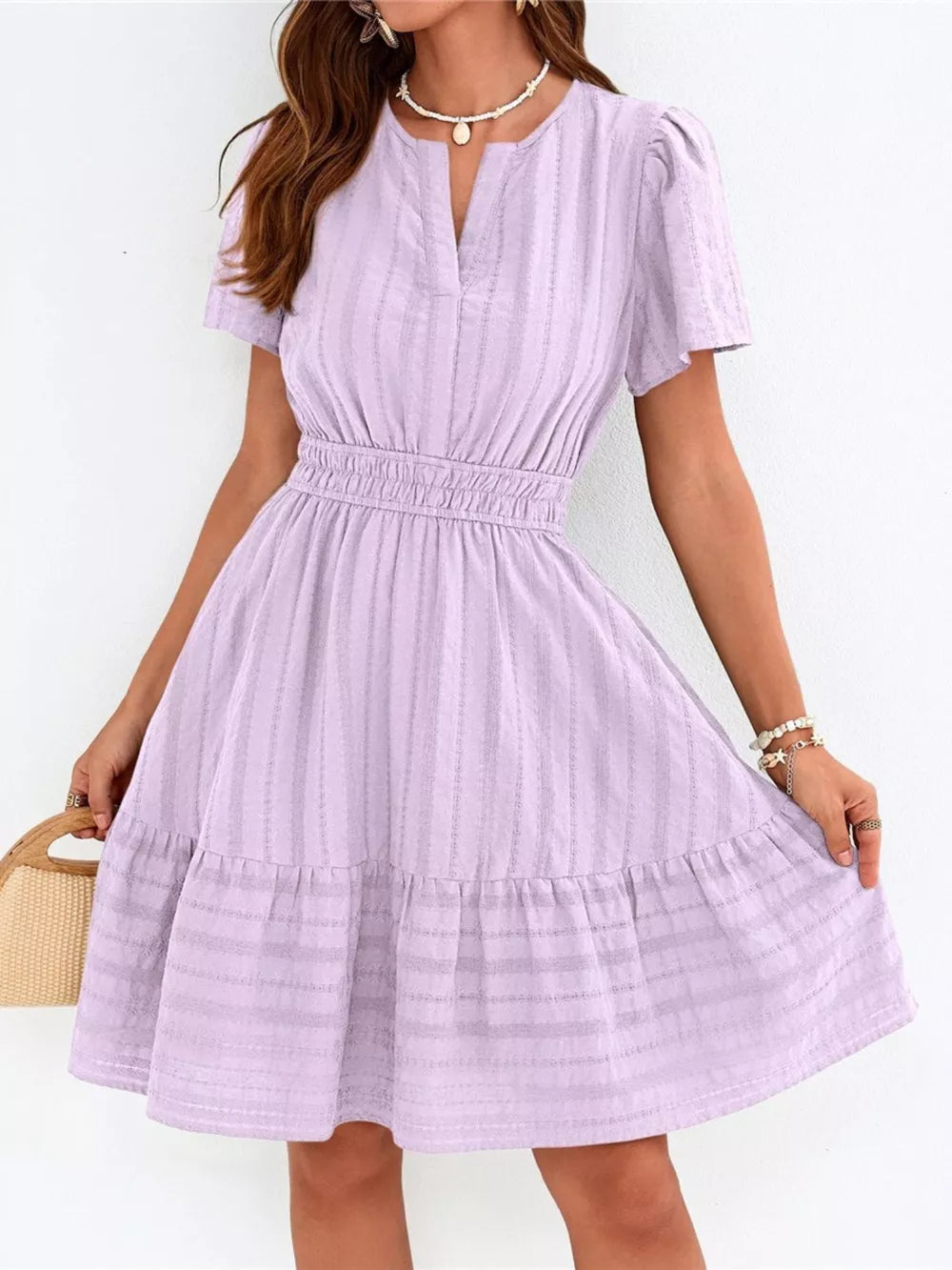 Textured purple V-neck tiered dress with smocked waist and short sleeves.