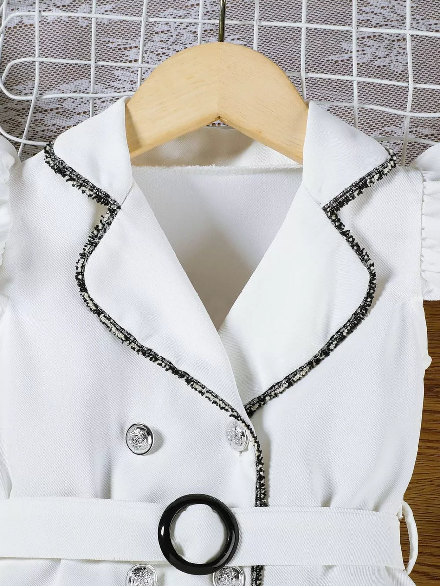 White toddler dress with double-breasted detail, black trim, silver buttons, and belt.