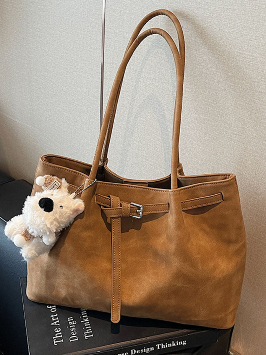 Brown shoulder bag with buckle accent and plush charm
