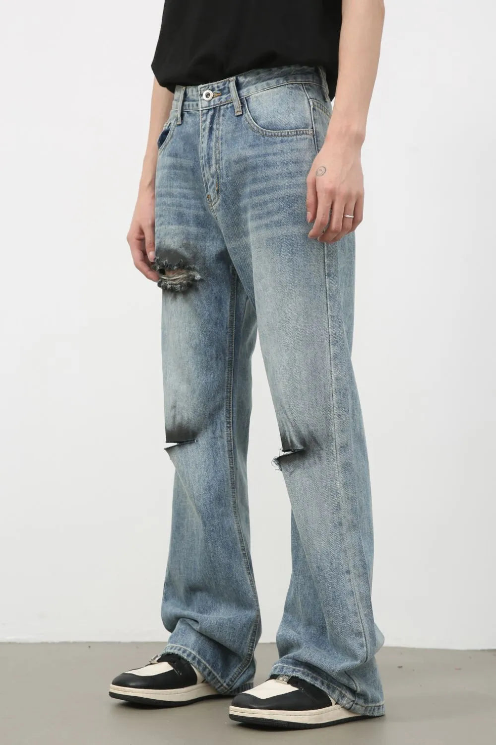 Distressed flare leg jeans in medium wash cotton with ripped details.