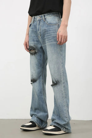 Distressed flare leg jeans in medium wash cotton with ripped details.