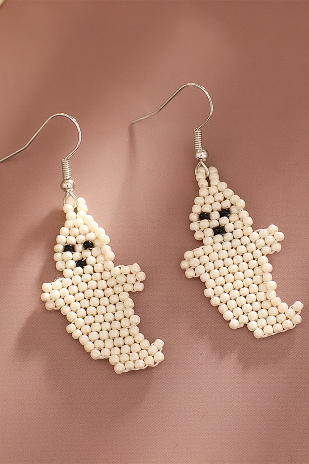 Beaded ghost fringe earrings in ivory with black bead eyes and mouth.