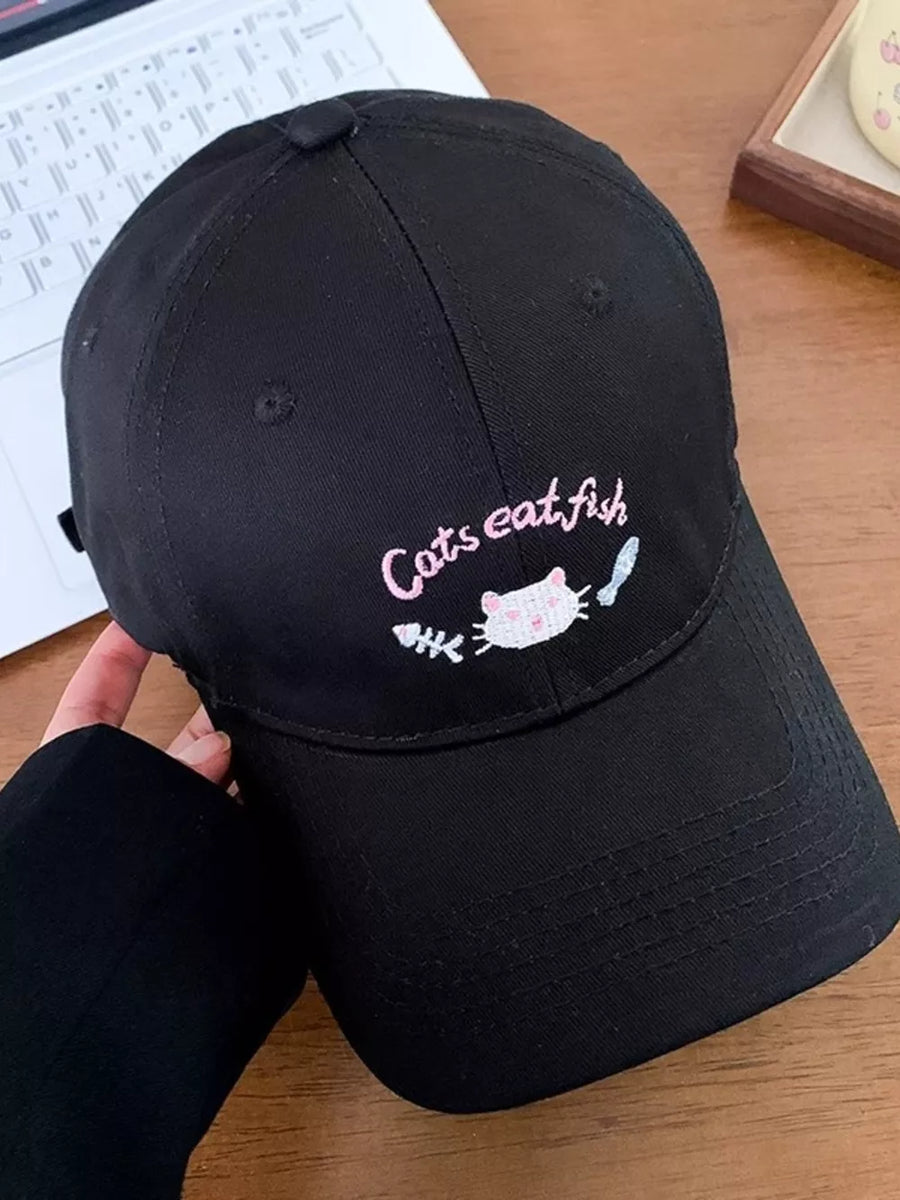 Black baseball cap with embroidered cat and fish graphic and text.