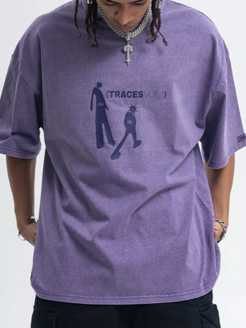 Purple oversized graphic tee with relaxed fit, 100% cotton, featuring abstract figures and text.