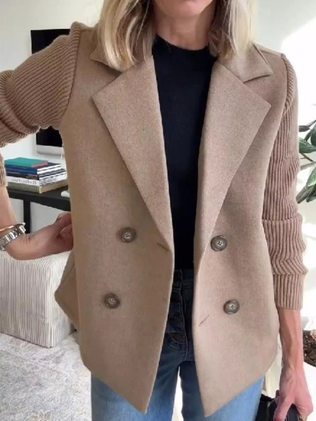 Tan double-breasted trench coat with knit sleeves and button closure.