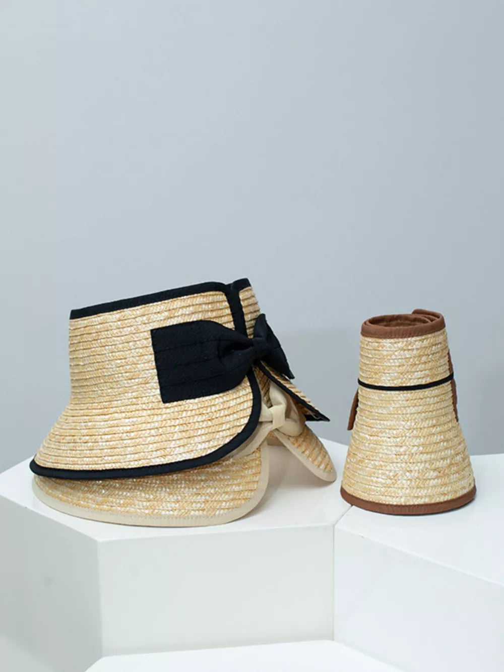 Straw visor hat in off-white with black trim and bow detail