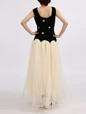 Black velvet sleeveless dress with floral embellishments and a cream tulle skirt.