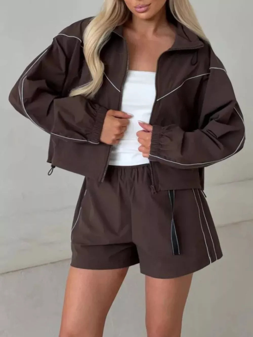 track jacket in dark brown featuring contrast stitching and relaxed fit