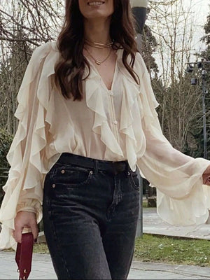 Beige sheer long-sleeve blouse with ruffles and a V-neck.
