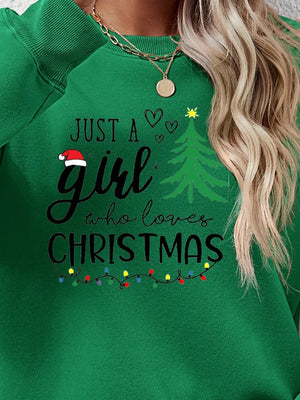 Green crewneck sweatshirt with "Just a girl who loves Christmas" graphic and string lights.