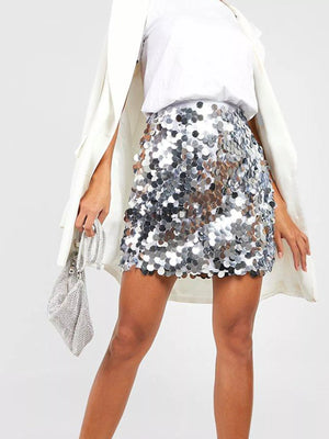 Women's silver sequin mini skirt with a scalloped hem, styled with a blazer.