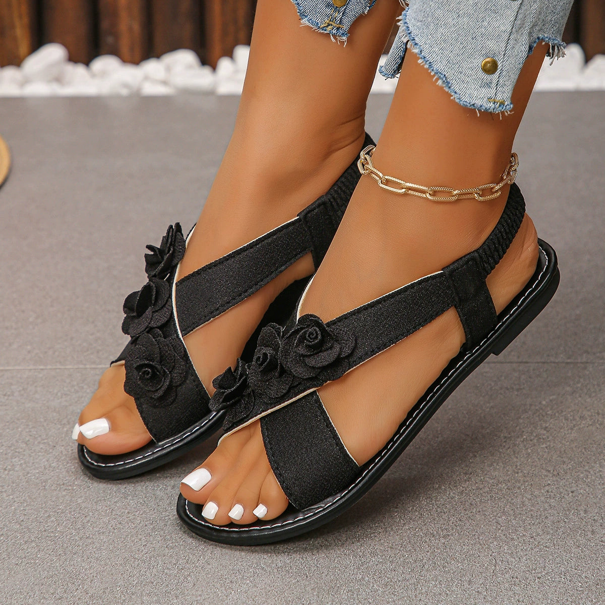 Black slingback sandals with floral embellishments and comfort straps.