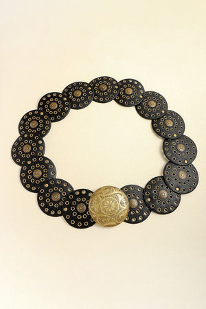 Black leather belt with round gold-tone disc embellishments and a large ornate gold buckle.