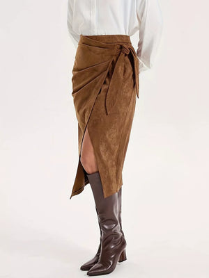 Brown suede midi skirt with tie detail and front slit, styled with boots.