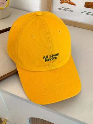 Yellow baseball cap with embroidered "All Lives Revive" text detail