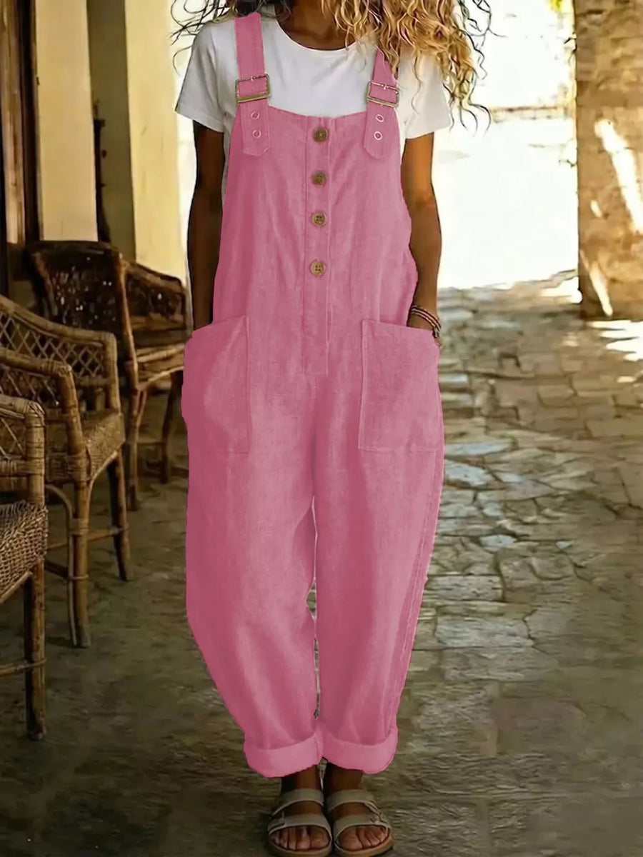 Pink wide leg romper with buttons and pockets, cuffed ankles, worn over a white t-shirt.