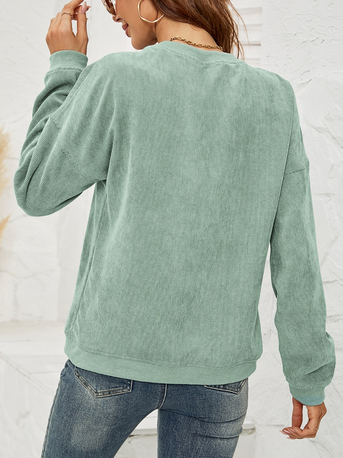 Sage green corduroy sweatshirt with crewneck and long sleeves.
