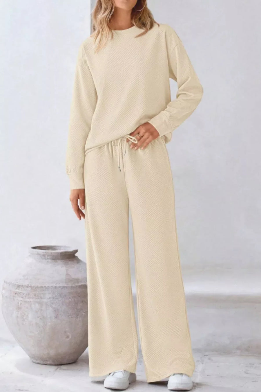 Apricot loungewear set with drawstring pants and a textured crewneck sweatshirt.