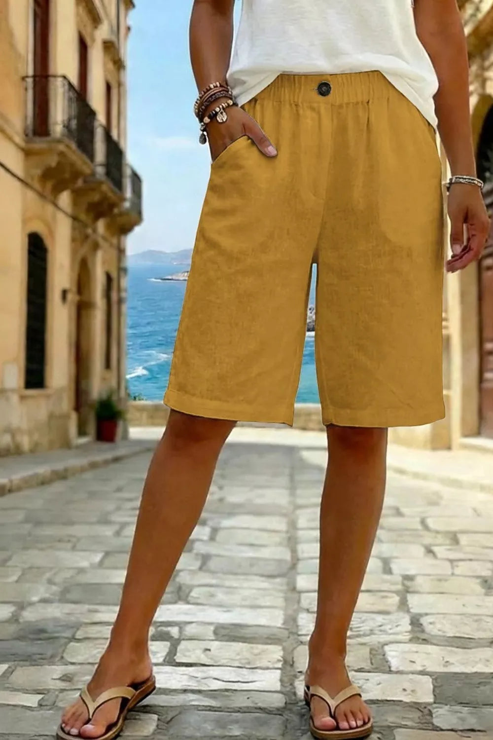 Mustard pocketed knee-length shorts with elastic waist and button detail