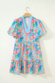 Tropical floral print V-neck dress with tiered skirt and scalloped trim detail.