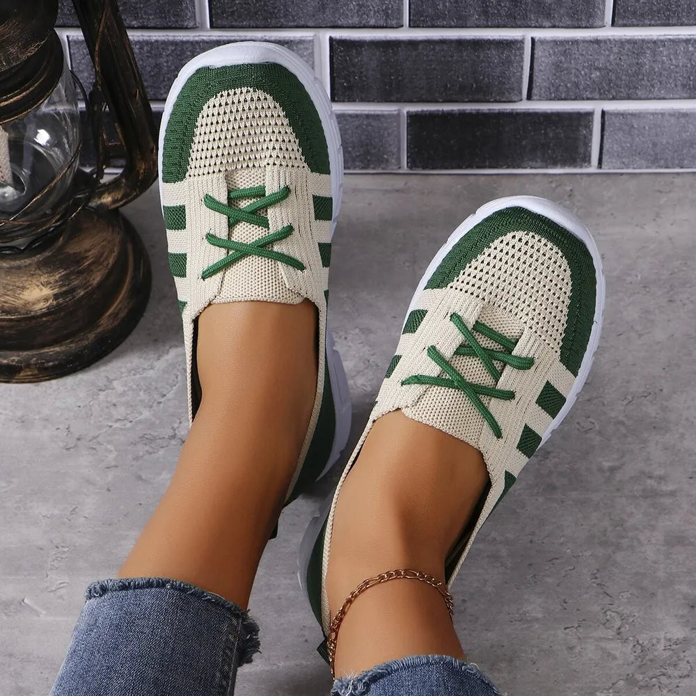 Breathable knit lace-up sneakers in beige with green accents and white soles.