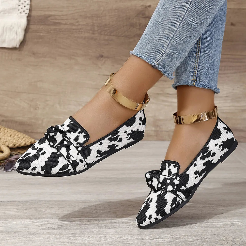 Knot Detail Knit Flats in Cow Print pattern with a bow detail.