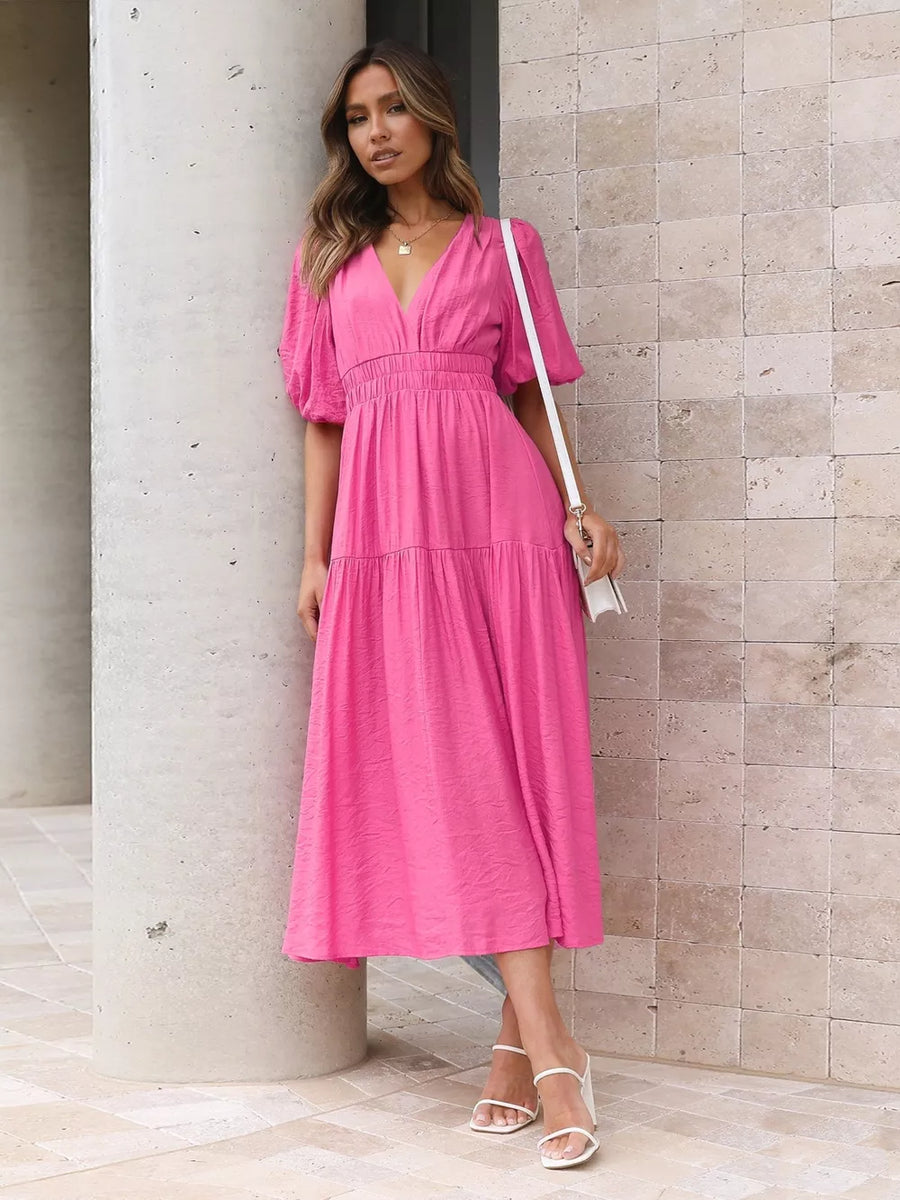 Hot pink midi dress with puff sleeves and tiered skirt.
