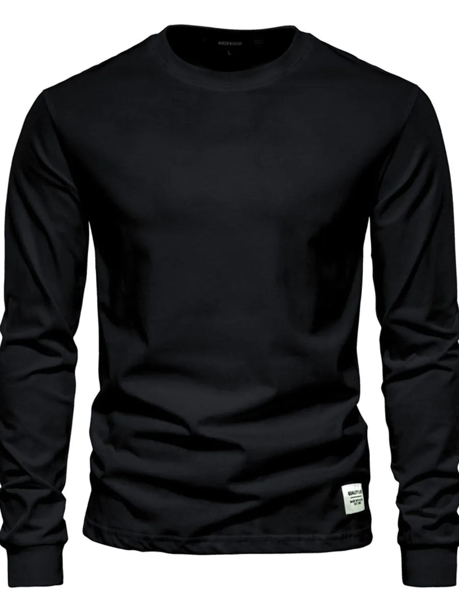 Black crewneck long sleeve t-shirt with a small white tag detail on the hem.