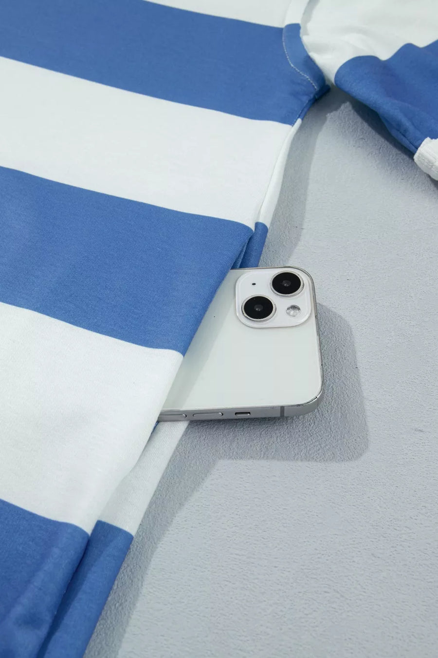 Blue and white striped t-shirt dress with side pocket holding a smartphone.
