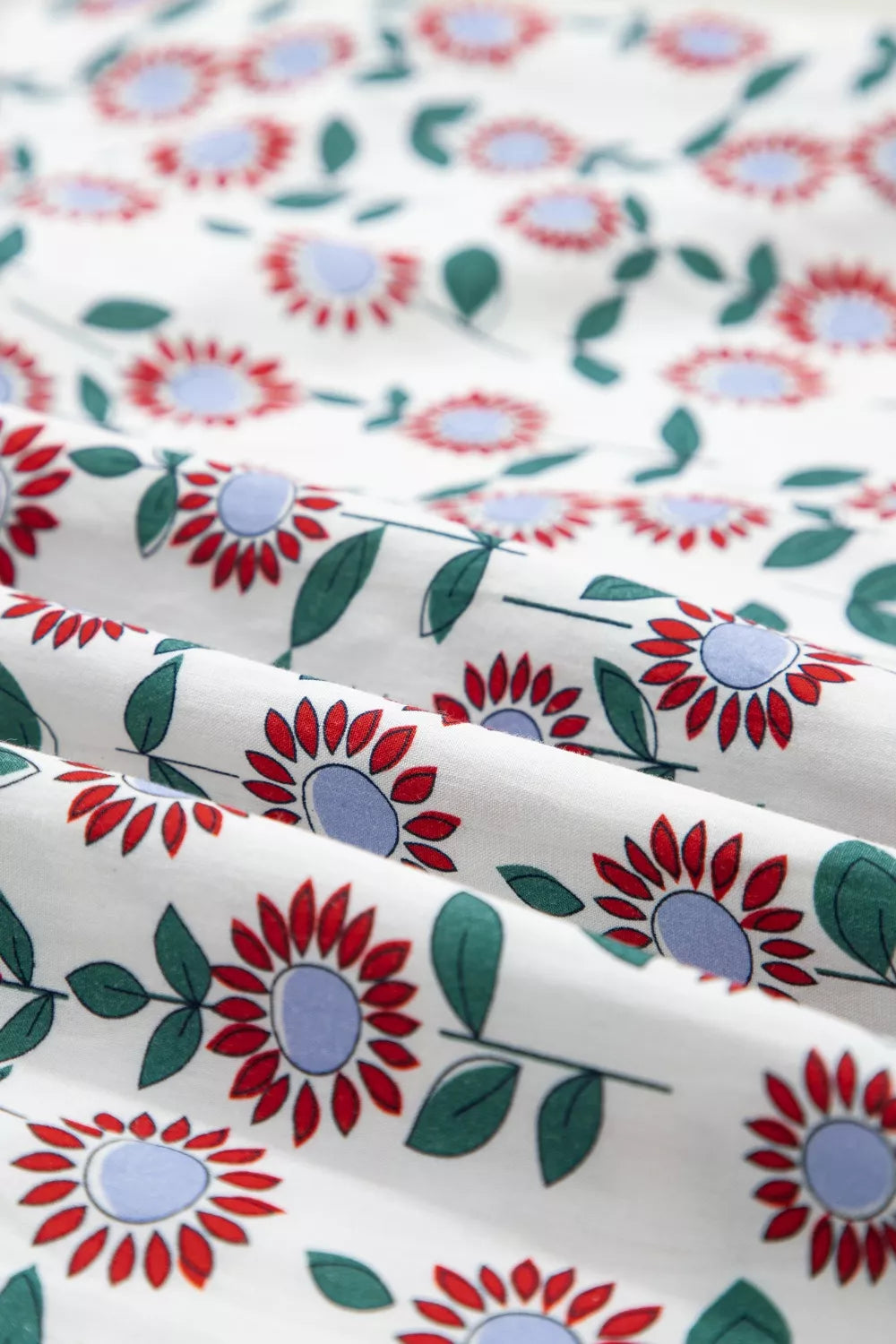 Vibrant floral midi dress in white cotton with red flowers and green leaves.