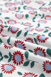 Vibrant floral midi dress in white cotton with red flowers and green leaves.