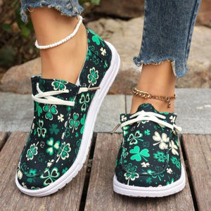 Clover print canvas slip-on sneakers with white decorative laces and white soles.