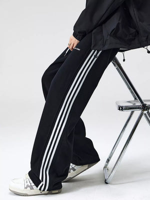 Black sweatpants with white side stripes and a drawstring waist.
