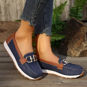 Blue denim round toe slip-on loafers with brown trim and silver buckle detail.