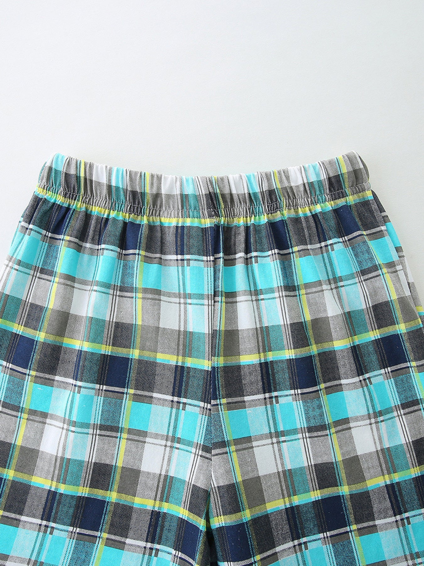 Boys' plaid shorts with elastic waistband in blue, gray, white, and yellow.