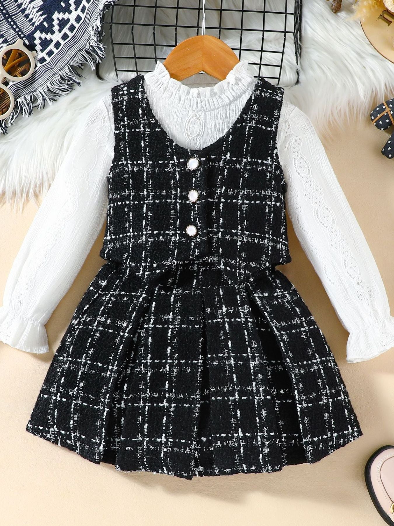 Toddler black and white plaid vest and long sleeve top set with decorative buttons.