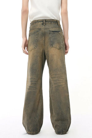 Whiskered denim straight leg jeans in taupe with a distressed wash and relaxed fit.
