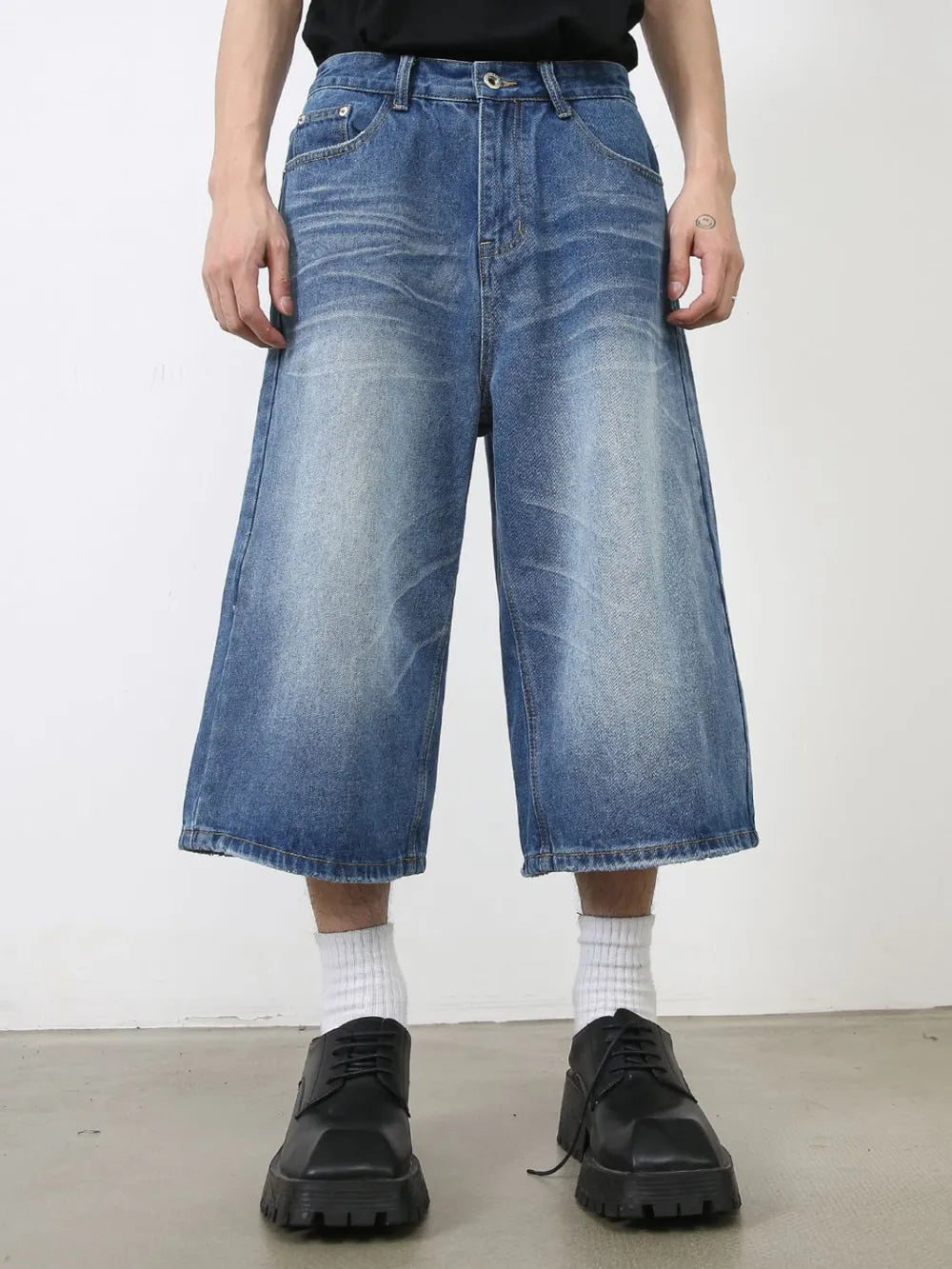 Wide-leg denim culotte shorts in blue wash with a relaxed fit and buttoned front.