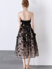 Black midi dress with 3D floral applique and a strapless neckline.