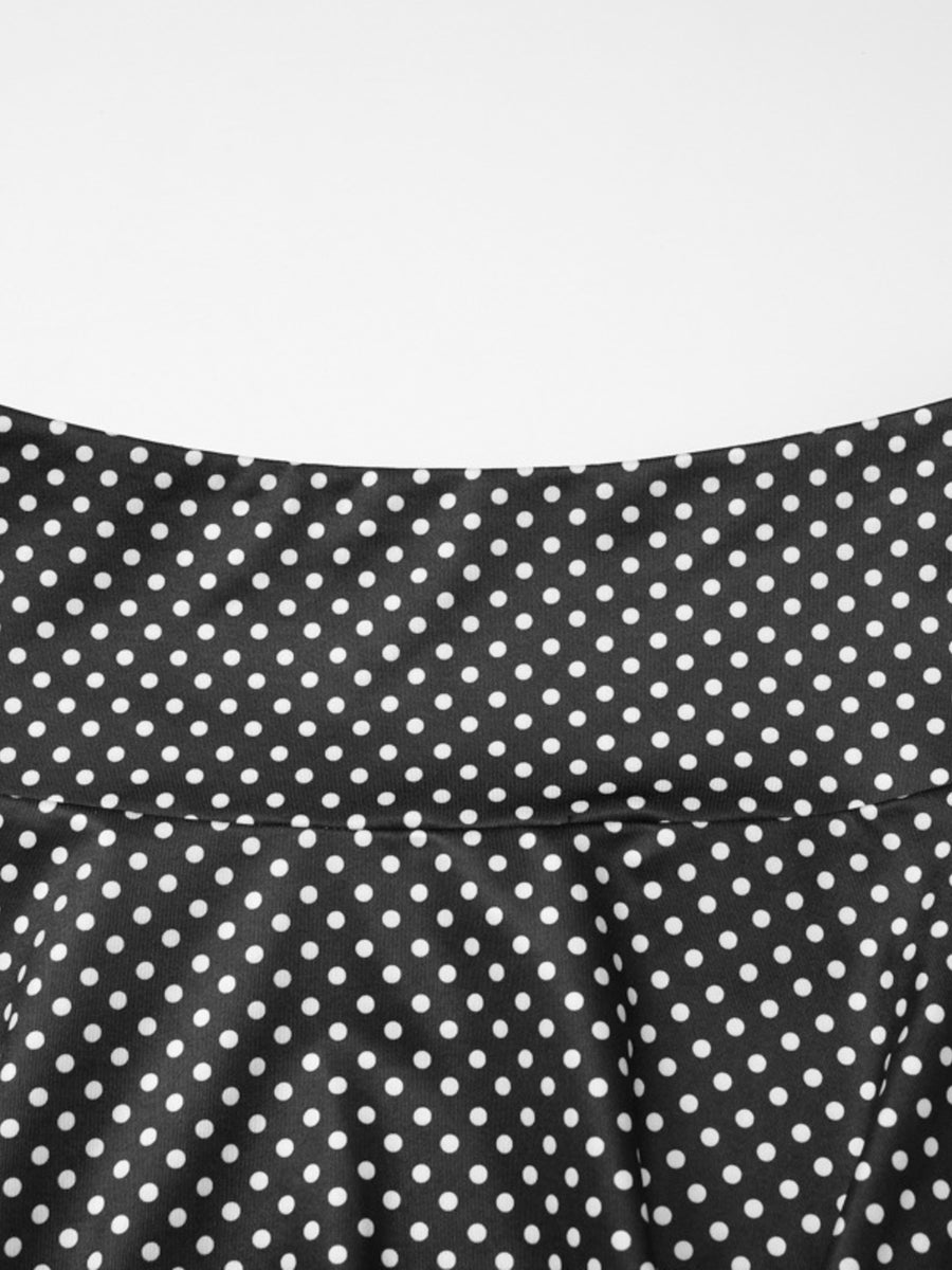 Black polka dot two-piece set with ruffled crop top and flared skirt detail.