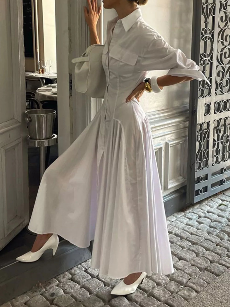 White cotton shirt dress with full skirt, button front, and pocket details.