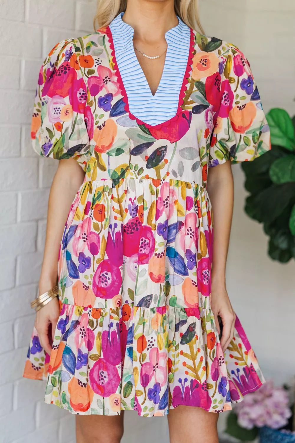 Vibrant floral cotton mini dress with tiered skirt and puff sleeves.