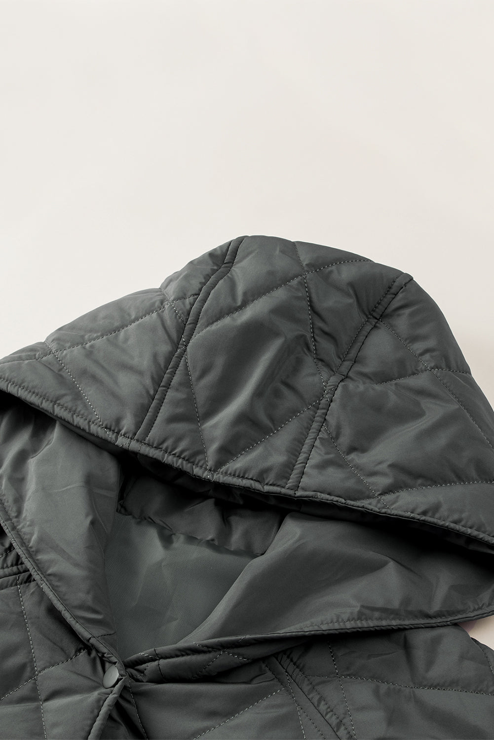 Diamond quilted hooded snap jacket in light gray with visible snap closure detail.