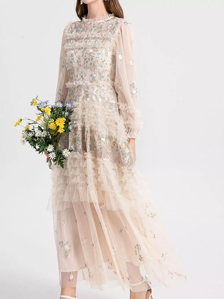Embroidered floral tulle maxi gown with ruffles and long sleeves.