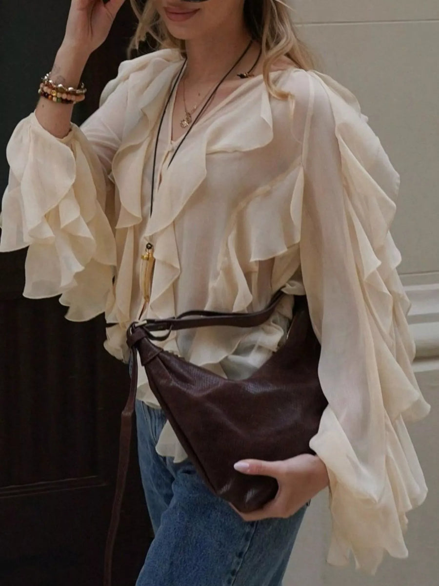 Beige sheer long-sleeve blouse with cascading ruffles and a V-neckline.