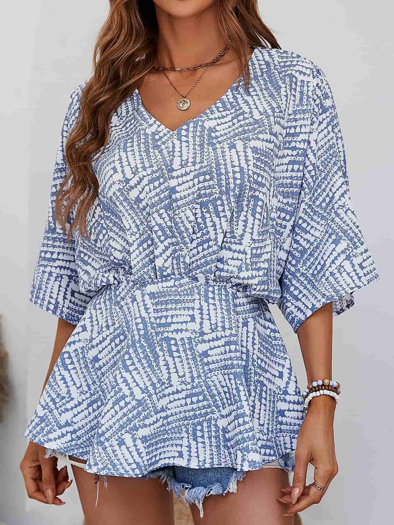 Light blue abstract print cinched waist blouse with V-neck and short sleeves.