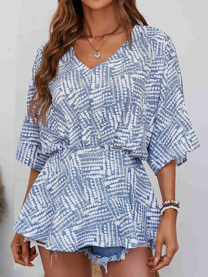 Light blue abstract print cinched waist blouse with V-neck and short sleeves.
