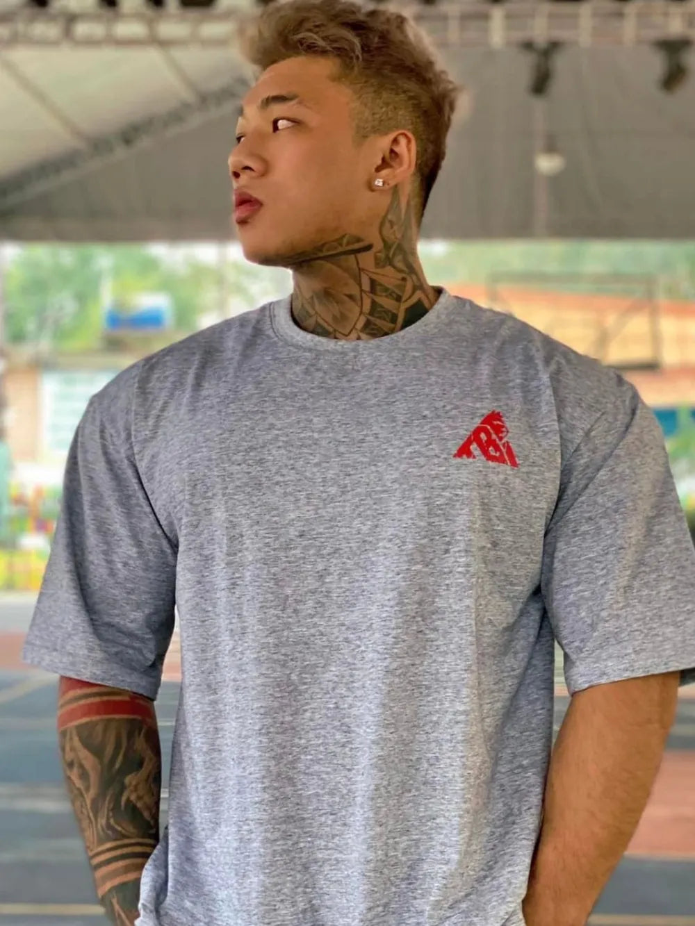 Gray oversized t-shirt with a small red graphic logo on the chest.