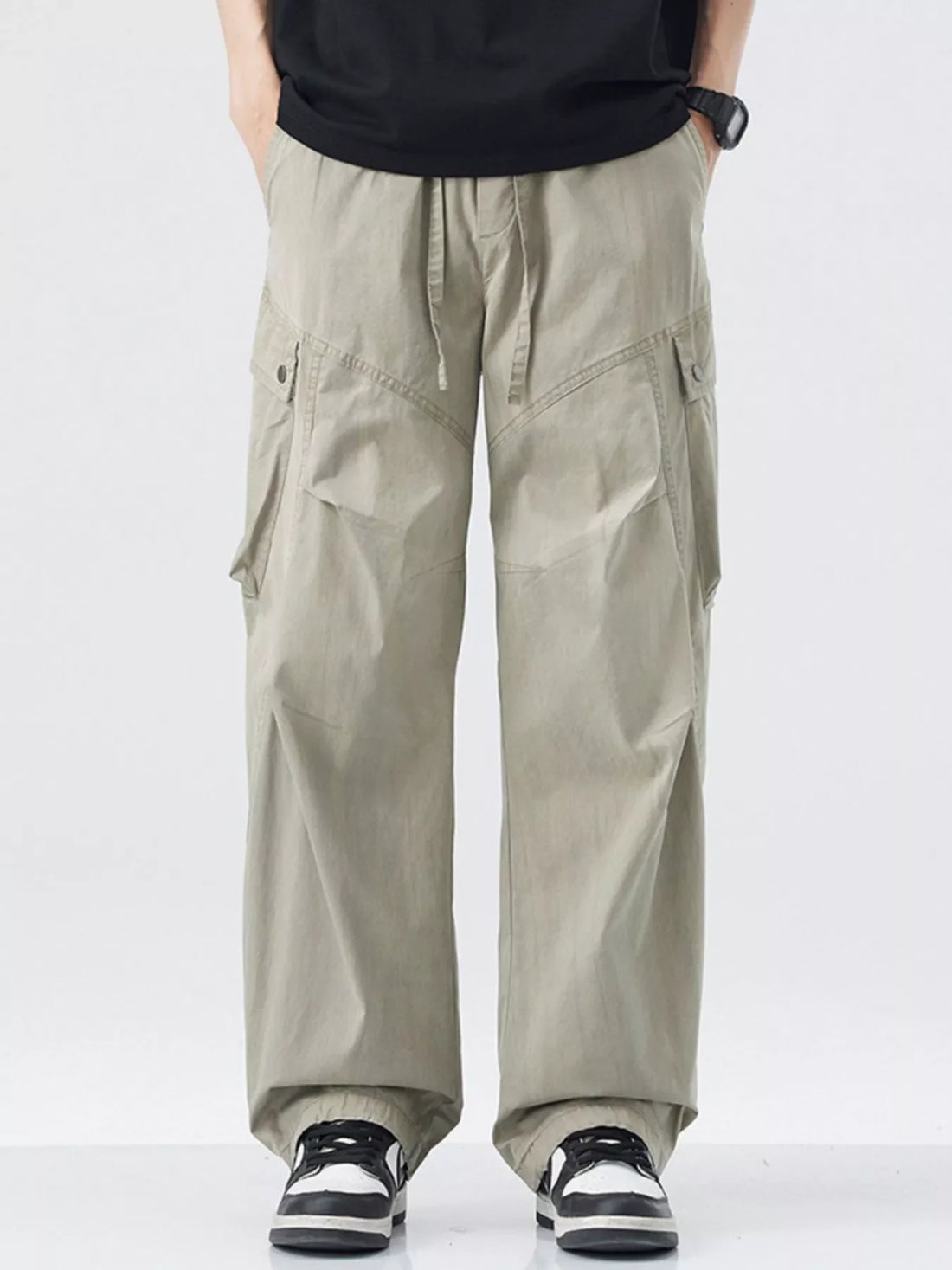 Loose fit khaki cargo pants with drawstring waist and multiple pockets.